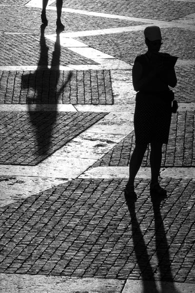 Black and white photo of people and their shadows by Piero Leonardi