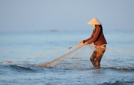 Photo of woman fishing in Mui-Ne, Vietnam by Ron Veto