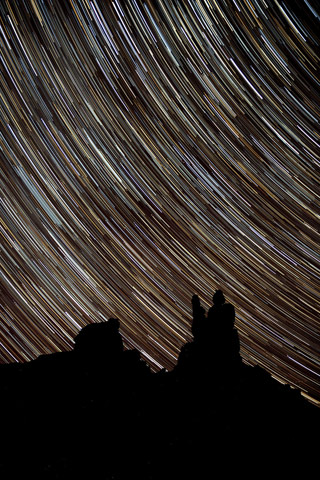 Star Trails photography: star trails over silhouetted rock formations at Valley of the Gods, Utah by Andy Long.
