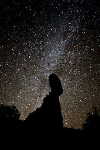 Star photography: stars over silhouetted Balanced Rock at Arches National Park, Utah by Andy Long.