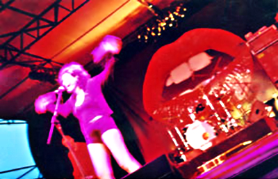 Color image make with slowe shutter speed of Deborah Conway performing on stage by Lisa J. Young.