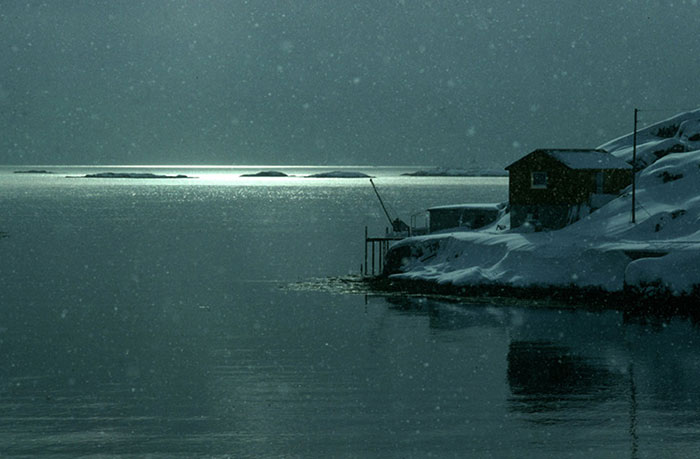 Winter photo of cabin on shore in Norway by Gert Wagner