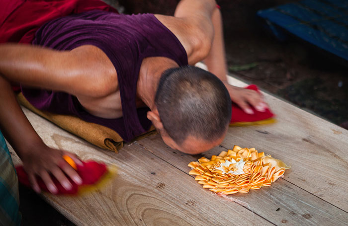 Photo of Buddhist monk doing prostrations at Mahabodhi Temple, Bodhgaya, India by Nico DeBarmore.