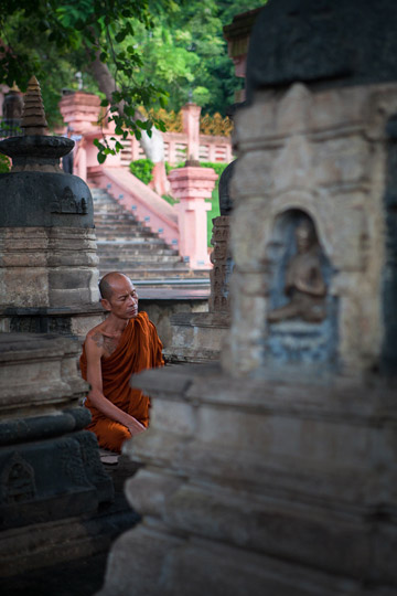 Photo of Buddhist monk meditating among the stupas at Mahabodhi Temple, Bodhgaya, India by Nico DeBarmore.