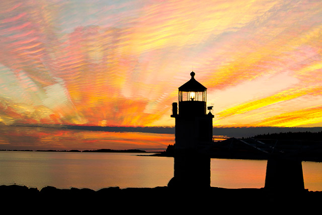 A sunset photo with many colors surrounds the Marshall Point Lighthouse in Rockland, Maine created by stacking 29 images by Andy Long.