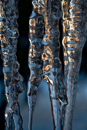 Macro photo of bluish, gold icicles showing reflected light, pattern and forms by Brad Sharp.