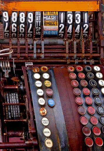 Close-up photo of an antique cash register with rows of colorful buttom by Brad Sharp