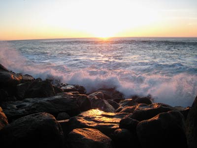 Image of California sunset over ocean waves and rocky shore by Marilyn S. Goerler.