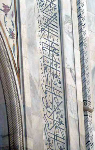 Close-up photo of the in-laid flowers and Koranic scripture on Taj Mahal by Rick Clark
