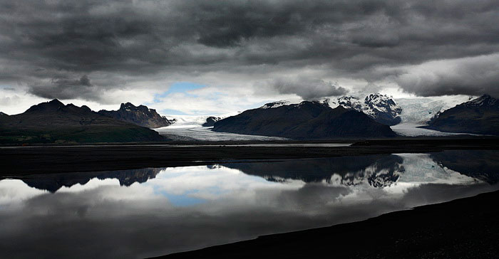 Image of storms clouds and mountains reflected on a lake in Iceland by Noella Ballenger.