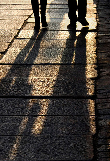Image of long shadows of people walking in Helsinki, Finland by Noella Ballenger.