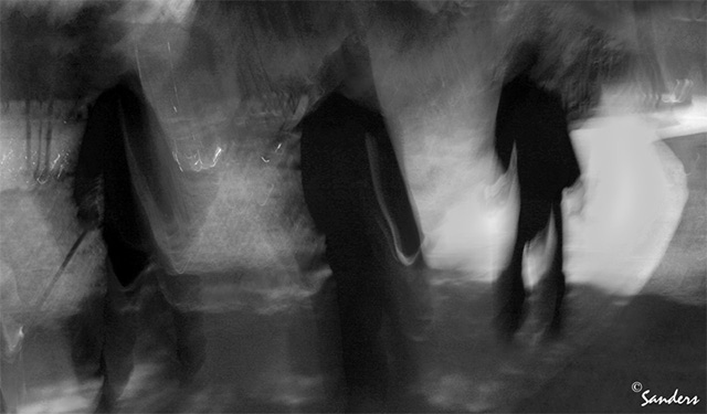 Photo Impressionism technique: black and white image of three people using a longer flowing camera shake by Gerald Sanders.