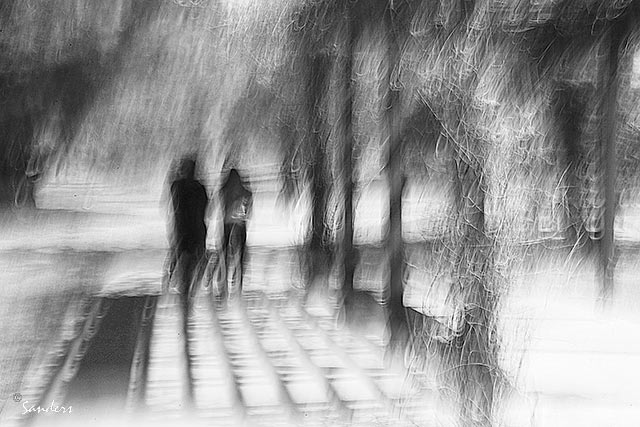 Photo Impressionism and camera shake technique: black and white image where leading lines move the eye to a couple on a path by Gerald Sanders.