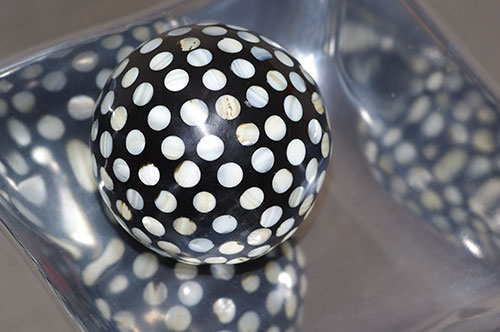 Image of ball with dots and silver bowl using indoor light with a hot shoe flash and no accessories by Marla Meier.
