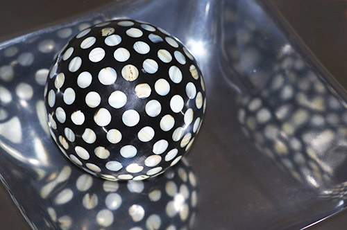 Image of ball with seashell dots and silver metal bowl using an on-camera flash by Marla Meier.