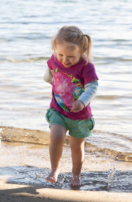 Photo portrait of a toddler on the beach running from the surf by Cathy Topping.