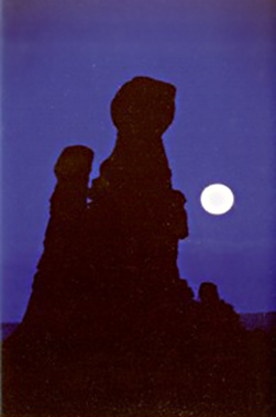 Full moon photography: silhouetted rock formations in front of full moon by Andy Long.