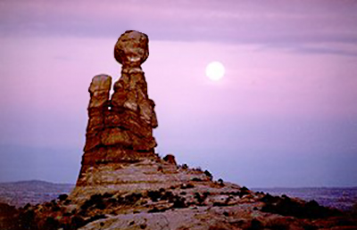 Full moon photography: sunset image of rock formations in front of full moon by Andy Long.