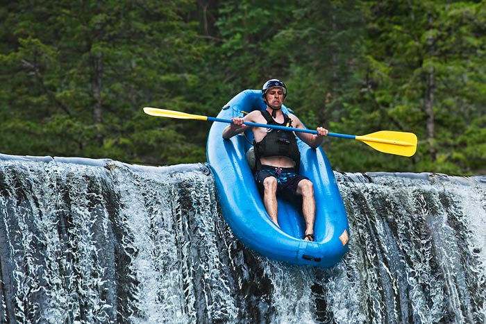 Stop action photography: Rafter going over waterfall by Brad Sharp.