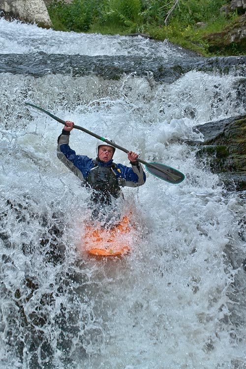 Stop action photography: Man kayaking in waterfall by Brad Sharp.