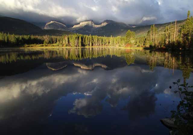 Photo adventures day hike: Continental Divide reflection in lake with dark, stormy clouds, Rocky Mountain National Park by Jeff Doran.