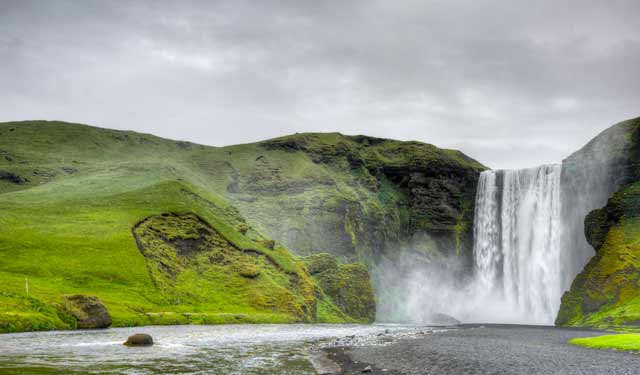 Photographic Travels in Iceland: Image of Skógafoss Falls and brilliant green landscape by Michael Legerro.