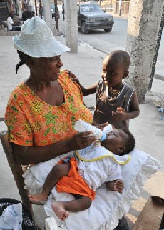 Photo of grandmother feeding grandson in Port-au-Prince
