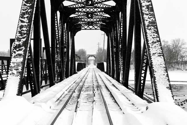 Black and white image looking down a train bridge in the snow by Randall Romano.