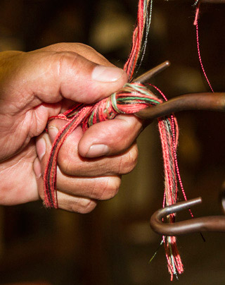 Photo of hands of man making a tassel at West Coast Trimming by Noella Ballenger