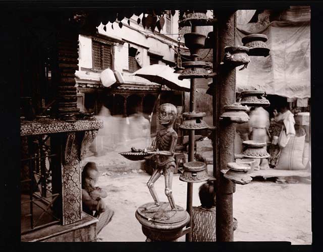 Black and white street scene of a Skeleton on Shrine, Kathmandu, Nepal by Linda Connor.