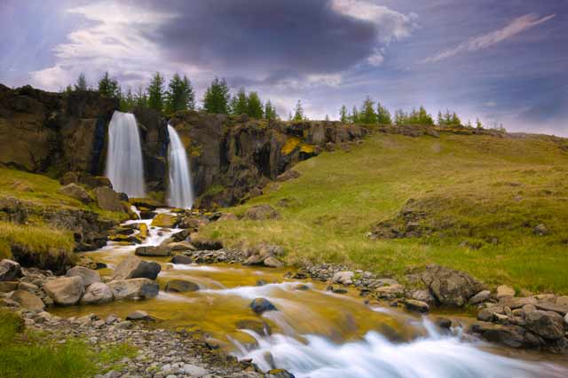 A roadside waterfall and stream in Iceland by Michael Leggero.