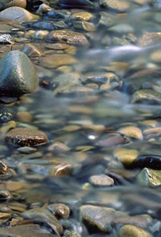 Close-up of stream water running over rocks by Andy Long.