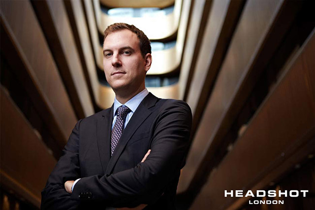 Corporate environmental portrait of a man standing within an office building by Headshot London Photography.