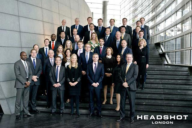 Corporate group portrait of men and women on building stairs by Headshot London Photography.