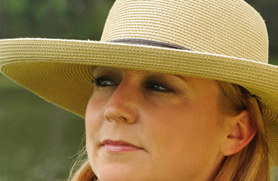 Close-up portrait of woman with hat using Lastolite gold reflector by Marla Meier