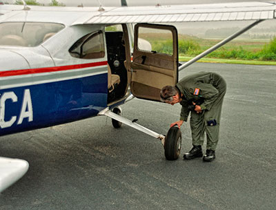 Aerial photography: Image of pilot doing a preflight check on a Cessna 182 by Allen Moore.