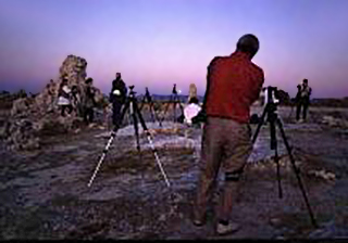 Participants of a photo workshop are set up on the rocks to make colorful sunrise images by Noella Ballenger.