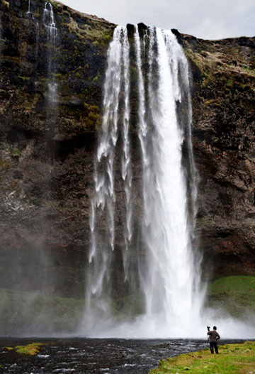 Participant of a photo workshop gets in closer to a waterfall in Iceland by Noella Ballenger.