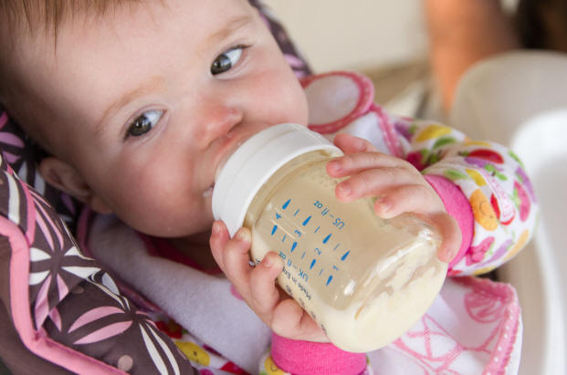 Image of Baby A holding her bottle of milk by Elizabeth Powis Fulks.
