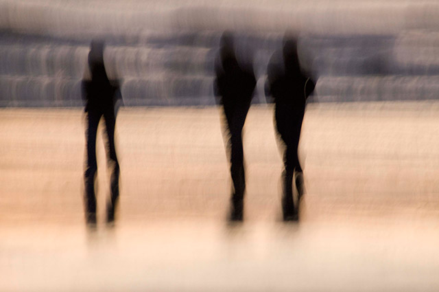 Impressionistic image of 3 silhouetted people by Eva Polak.